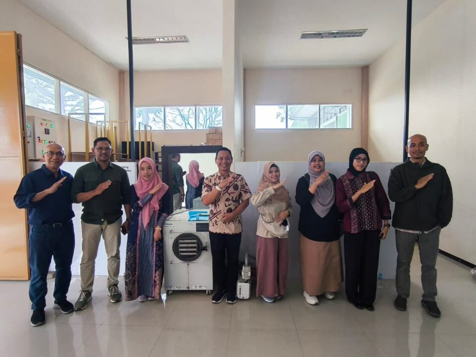 Tim Dosen FTAB Universitas Brawijaya bersama jajaran PLUT KUMKM Kota Batu berpose bersama di samping mesin freeze drying.