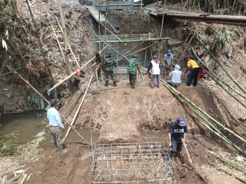 Personel Koramil 0833-02/Kedungkandang bersama masyarakat setempat sedang meninjau pengecoranpondasi Jembatan Perintis Garuda di wilayah Cemorokandang, Kecamatan Kedungkandang, Kota Malang.