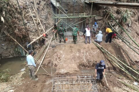 Personel Koramil 0833-02/Kedungkandang bersama masyarakat setempat sedang meninjau pengecoranpondasi Jembatan Perintis Garuda di wilayah Cemorokandang, Kecamatan Kedungkandang, Kota Malang.