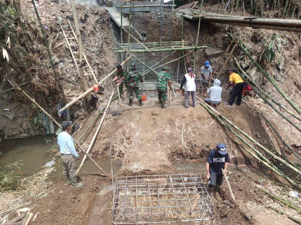 Personel Koramil 0833-02/Kedungkandang bersama masyarakat setempat sedang meninjau pengecoranpondasi Jembatan Perintis Garuda di wilayah Cemorokandang, Kecamatan Kedungkandang, Kota Malang.