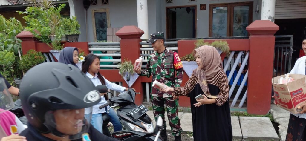 Babinsa Bumiayu Koramil 0833-02/Kedungkandang, Koptu Aris, bersama warga dan pemuda setempat membagikan paket makanan kepada pengendara motor dalam aksi sosial Jumat Berkah di kawasan Bumiayu, Kedungkandang, Kota Malang, Jumat (2/10).