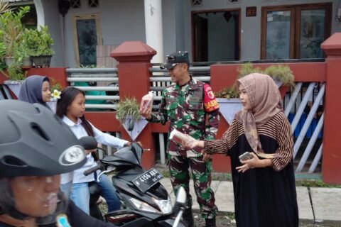 Babinsa Bumiayu Koramil 0833-02/Kedungkandang, Koptu Aris, bersama warga dan pemuda setempat membagikan paket makanan kepada pengendara motor dalam aksi sosial Jumat Berkah di kawasan Bumiayu, Kedungkandang, Kota Malang, Jumat (2/10).