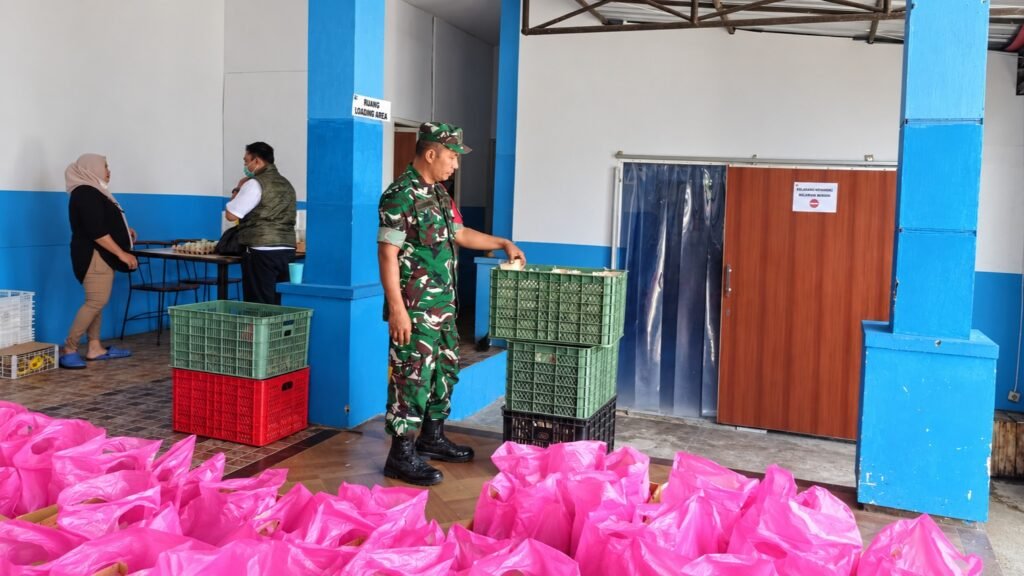 Babinsa Tlogomas Sertu Sugeng saat mendampingi proses penyiapan dan pengecekan paket makanan bergizi di wilayah binaan