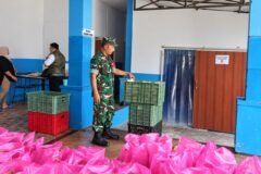 Babinsa Tlogomas Sertu Sugeng saat mendampingi proses penyiapan dan pengecekan paket makanan bergizi di wilayah binaan