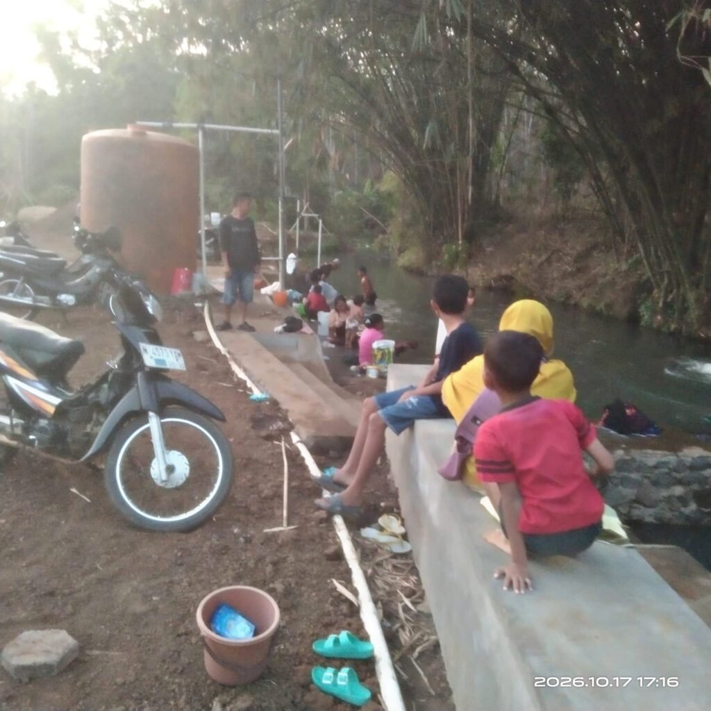 Dari dana pribadi Rp100 juta, ia bangun fasilitas cuci-mandi gratis. Berawal dari kenangan pahit mencuci di sungai desa orang, kini warga banyak desa terbantu. Rencananya: dua titik baru dan usaha air isi ulang pH 7,2.