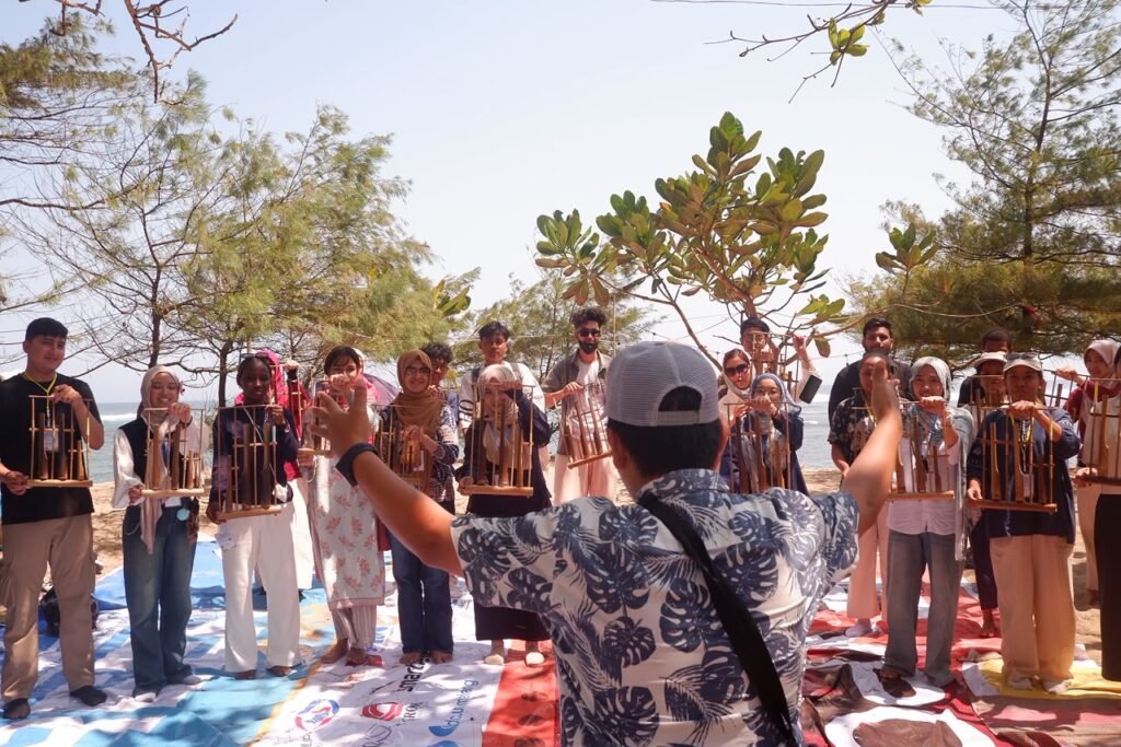 Mahasiswa internasional sedang bermain angklung di Pantai Balekambang