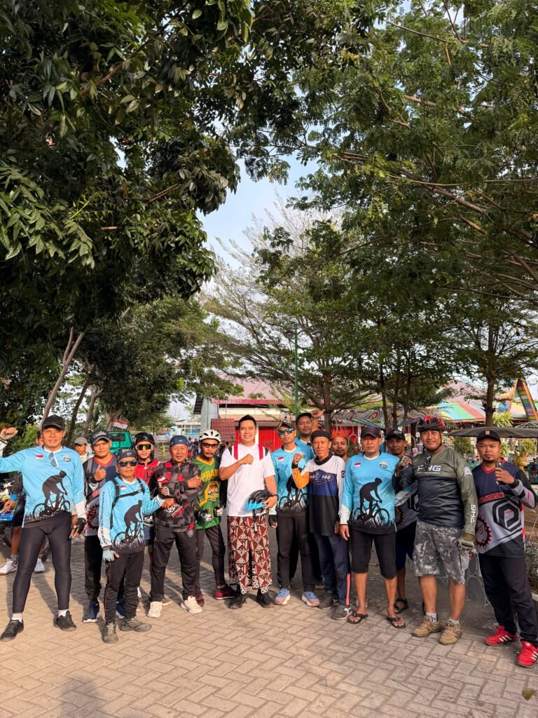 Muhammad Zaini kenakan kaos putih dan sarung ikut gowes