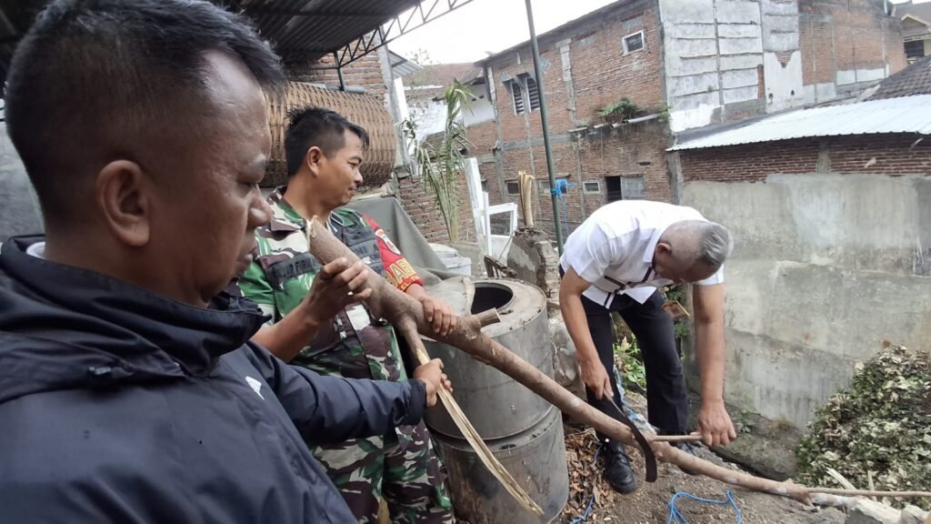 Babinsa Kelurahan Tulusrejo Koramil 0833-05/Lowokwaru, Serda Fajar, bersama warga dan petugas memotong dahan pohon yang tumbang ke dalam saluran drainase di kawasan Kelurahan Tulusrejo, Lowokwaru, Kota Malang, Sabtu (3/10).