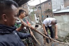 Babinsa Kelurahan Tulusrejo Koramil 0833-05/Lowokwaru, Serda Fajar, bersama warga dan petugas memotong dahan pohon yang tumbang ke dalam saluran drainase di kawasan Kelurahan Tulusrejo, Lowokwaru, Kota Malang, Sabtu (3/10).