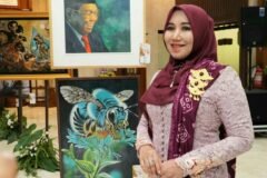 Anggota DPD RI Lia Istifhama berpose di samping deretan karya lukisan seni, termasuk lukisan KH Abdurrahman Wahid (Gus Dur), dalam kunjungan pameran seni di Gedung DPRD Jatim.