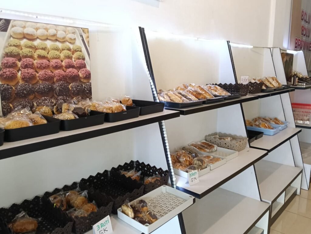 Berbagai varian produk roti dan bolu klasik yang tertata rapi di etalase toko.