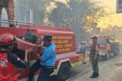 Serma Sudiono bersama petugas pemadam kebakaran dan warga berjibaku memadamkan api yang membakar rumpun bambu.