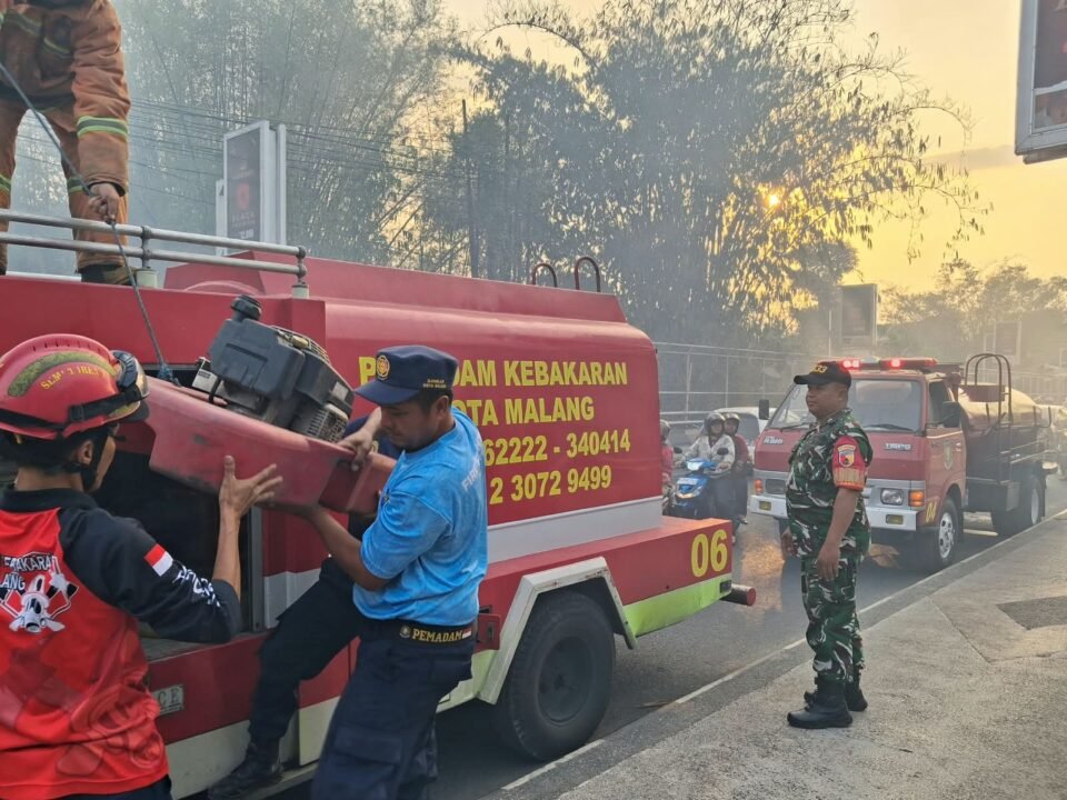 Serma Sudiono bersama petugas pemadam kebakaran dan warga berjibaku memadamkan api yang membakar rumpun bambu.