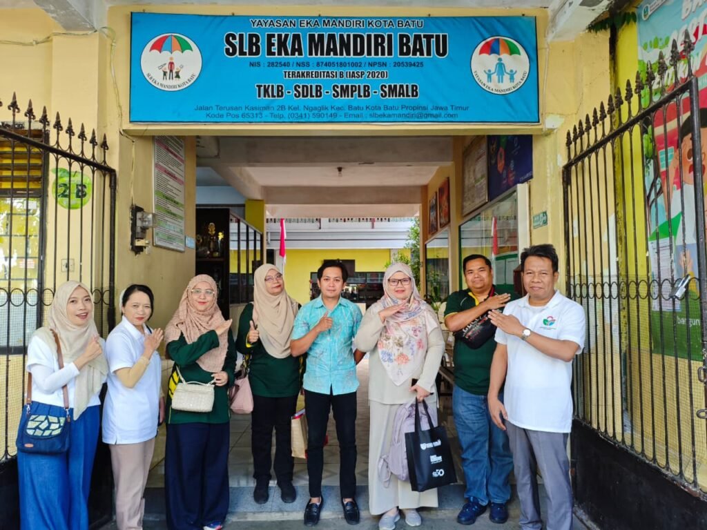 Tim kolaborasi UB, UPM, dan mitra instansi lokal berpose bersama di depan gerbang Yayasan SLB Eka Mandiri Kota Batu.