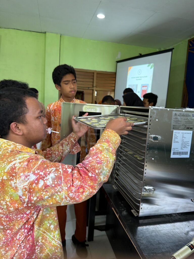 Siswa SLB Eka Mandiri Batu antusias mempraktikkan penggunaan food dehydrator untuk mengeringkan buah dalam sesi pelatihan pengolahan buah kering.