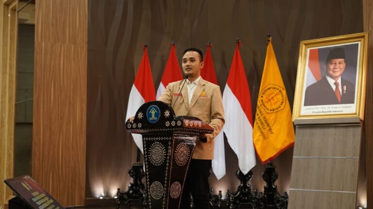 Ketua Umum DPN PERMAHI, Azhar Sidiq, saat memberikan pandangan hukum dan pernyataan sikap resmi, didampingi latar bendera organisasi dan foto resmi Presiden Republik Indonesia.