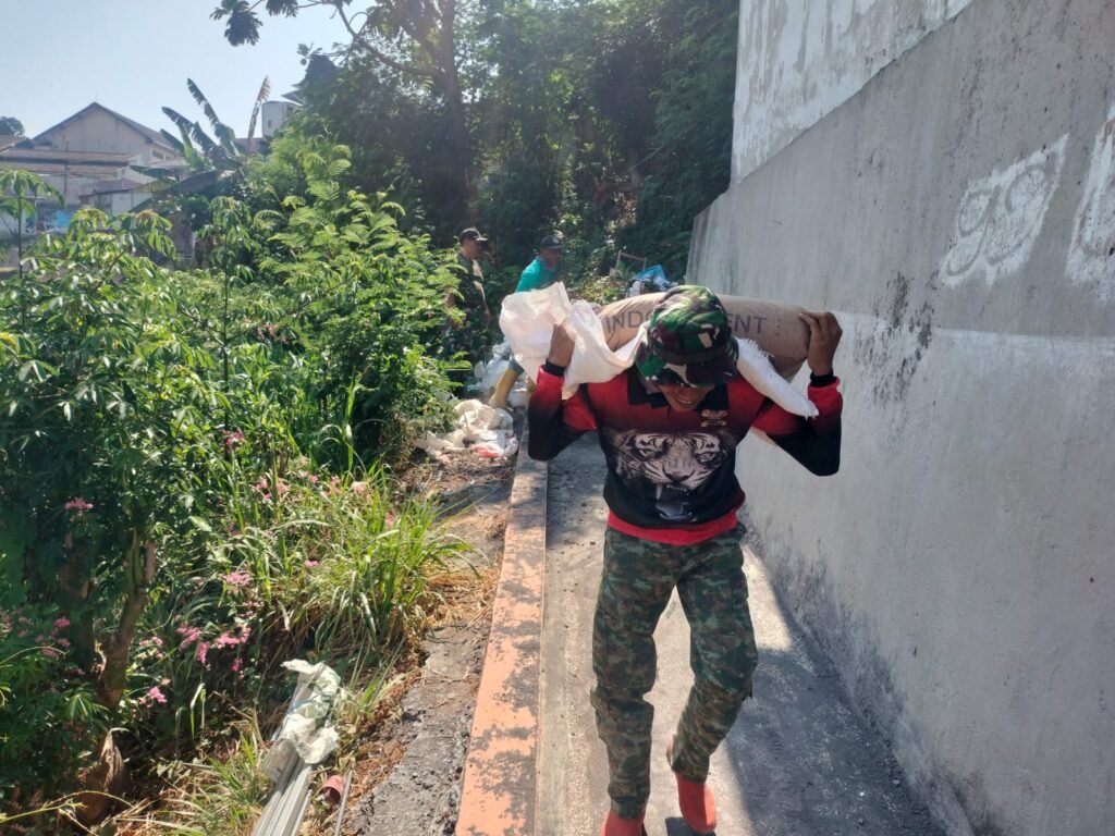 Aksi sigap seorang prajurit Babinsa tanpa lelah memanggul material semen demi mempercepat pembangunan jembatan.