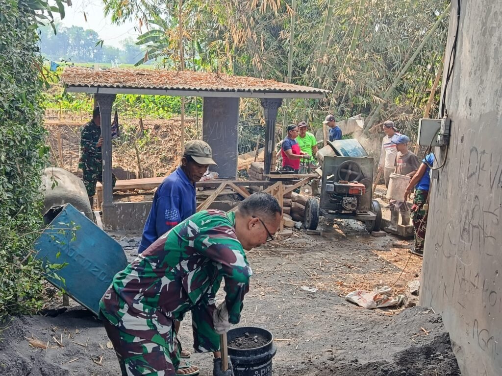 Danramil 0833-02/Kedungkandang Kapten Arief Sutedja bersama warga turun langsung menyiapkan material cor di lokasi proyek.