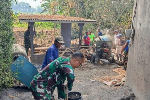 Danramil 0833-02/Kedungkandang Kapten Arief Sutedja bersama warga turun langsung menyiapkan material cor di lokasi proyek.