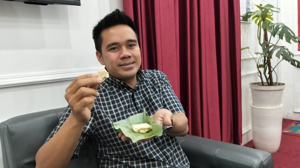 Muhammad Zaini menikmati tempe bungkus daun yang belum diolah produksi Irfan bermerk Zico