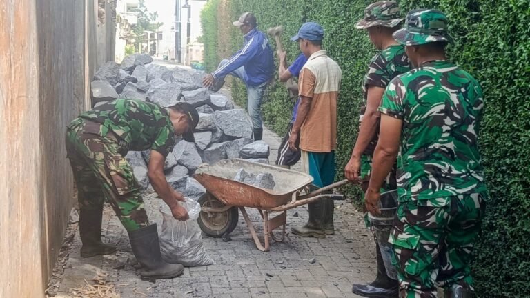Warga bersama personel Koramil 0833-02/Kedungkandang bahu-membahu mengangkut material batu dan cor untuk percepatan pembangunan pondasi Jembatan Garuda di Cemorokandang, Kota Malang.